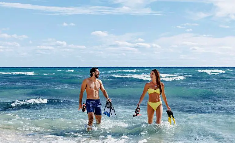 pareja en la playa con equipo de snorkel