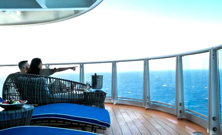 una pareja relajándose en el balcón de la suite de un crucero Carnival
