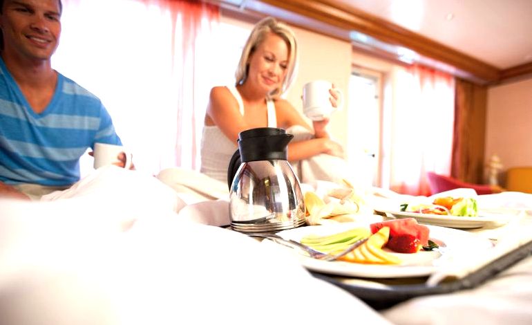 pareja desayunando en la cama en su luna de miel en un crucero de Carnival